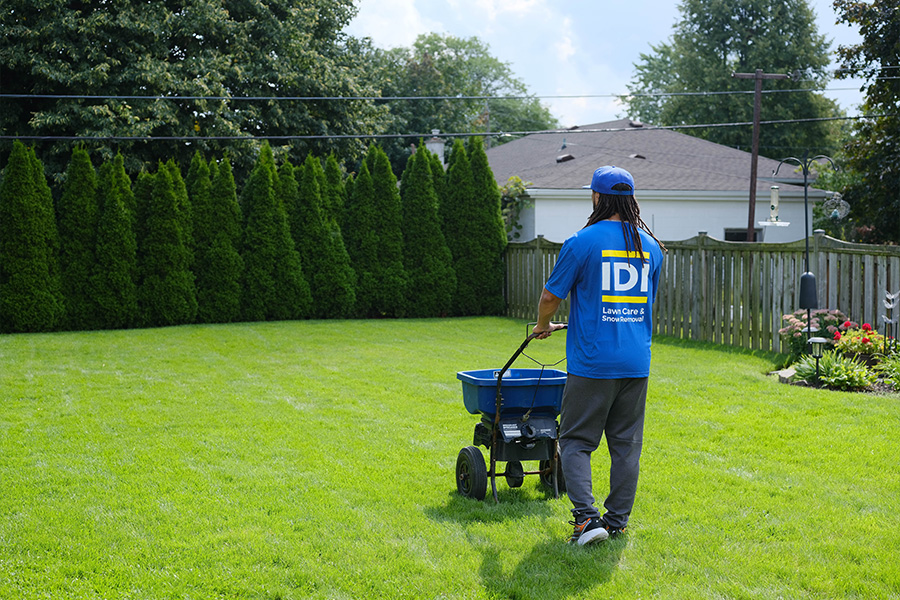 IDI employee applying fertilizer